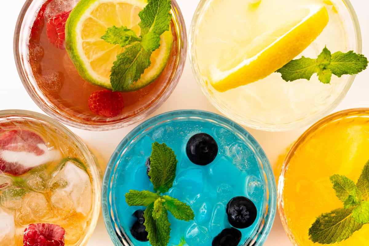 Colorful summer cocktails garnished with fresh berries and citrus